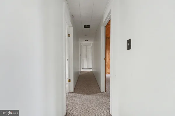 a view of a hallway with wooden shelves