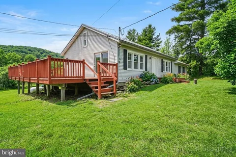 a view of a house with a yard and deck