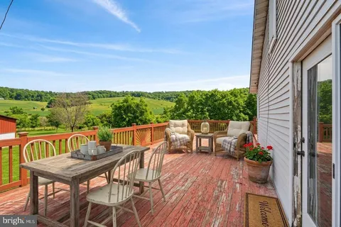 a view of a patio with couple of chairs and couches on the roof deck