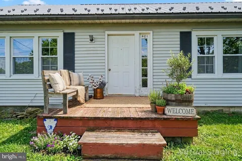 a front view of a house with garden and sitting area