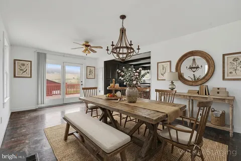 a view of a dining room with furniture a chandelier and wooden floor