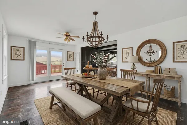 a view of a dining room with furniture a chandelier and wooden floor