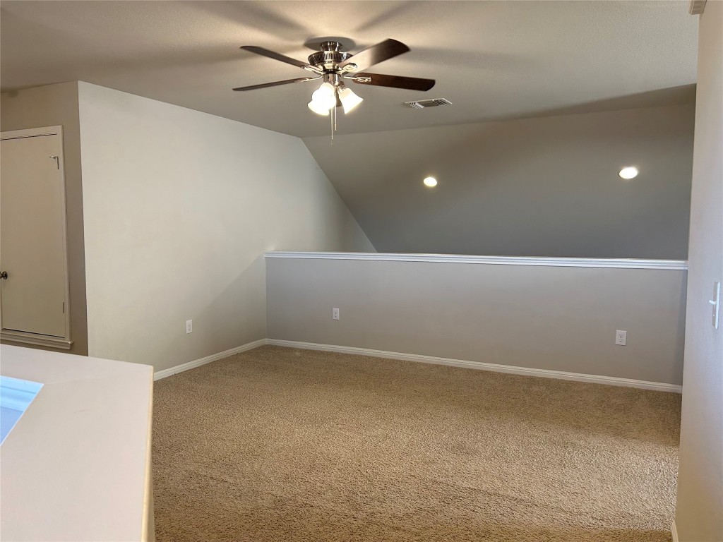 2212 Baugh Road Austin, TX 78754 - Photo 19 of 36 Spare room with lofted ceiling, light colored carpet, and a ceiling fan