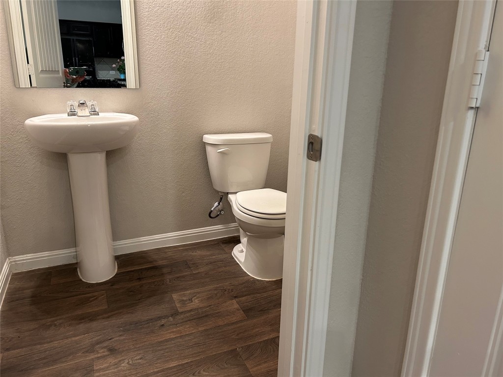 2212 Baugh Road Austin, TX 78754 - Photo 31 of 36 Half bathroom with dark wood finished floors and a textured wall