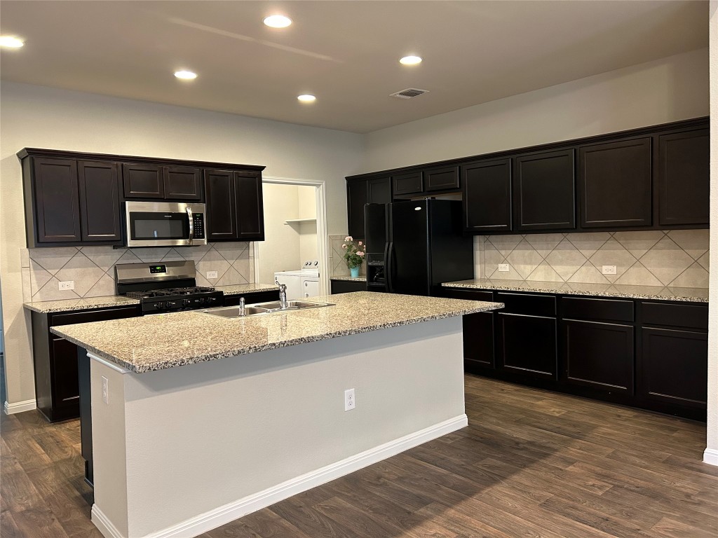 2212 Baugh Road Austin, TX 78754 - Photo 9 of 36 Kitchen with tasteful backsplash, stainless steel appliances, light stone counters, dark wood-style floors, and recessed lighting
