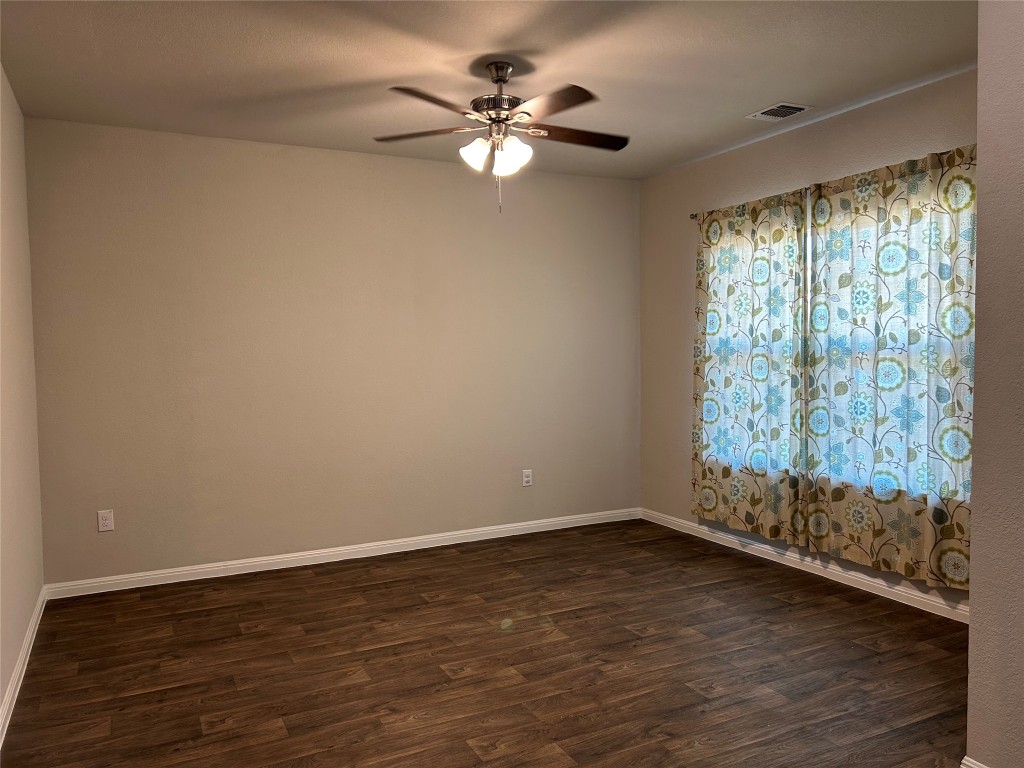 2212 Baugh Road Austin, TX 78754 - Photo 10 of 36 Spare room featuring dark wood-style flooring and a ceiling fan