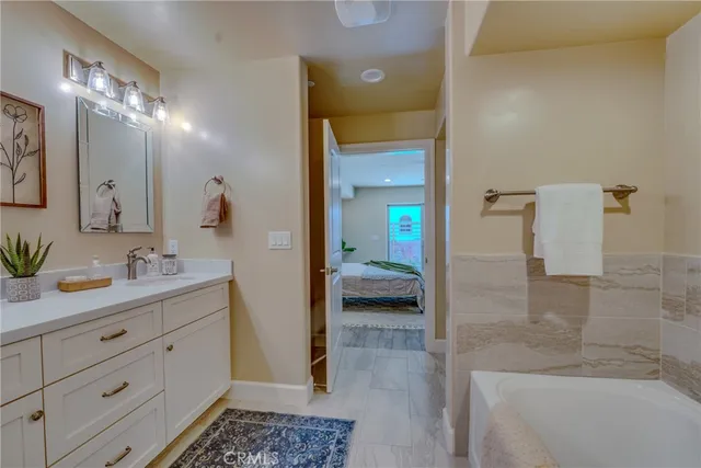 a spacious bedroom with a bed a table and a potted plant