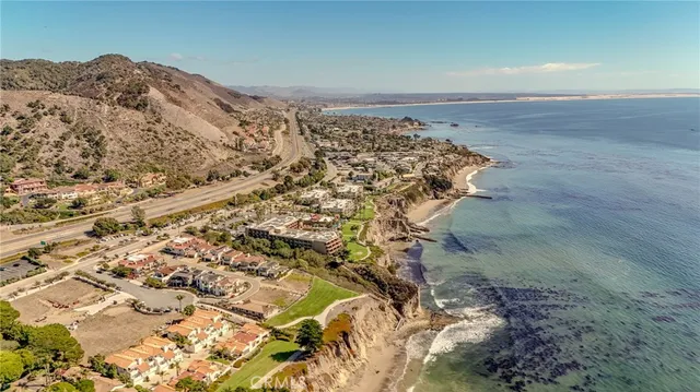 a kitchen with stainless steel appliances granite countertop a dining table chairs stove a refrigerator and cabinets