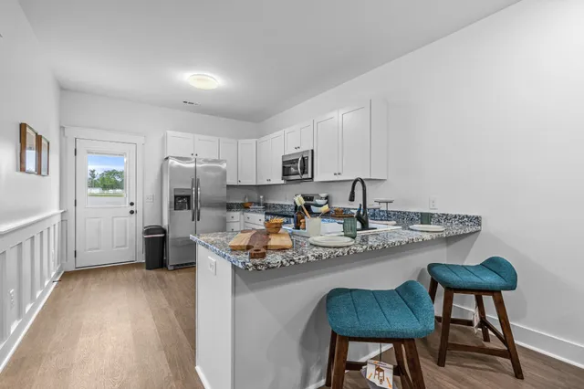 a kitchen with stainless steel appliances granite countertop a sink refrigerator and cabinets