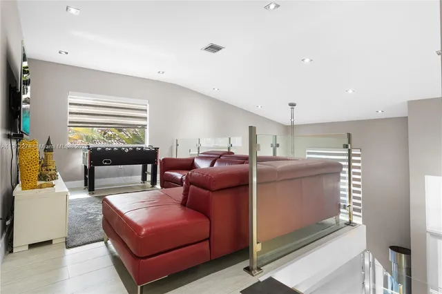a living room with furniture a flat screen tv and a window