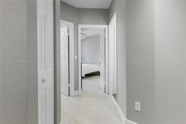 a view of a hallway with closet and bathroom
