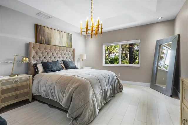 a bedroom with a bed chandelier and window