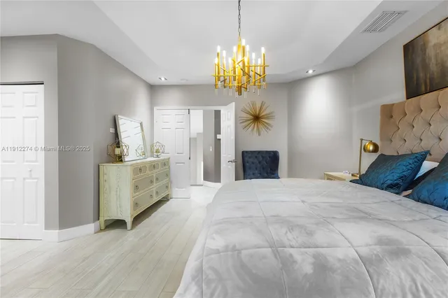 a bedroom with a bed and a chandelier