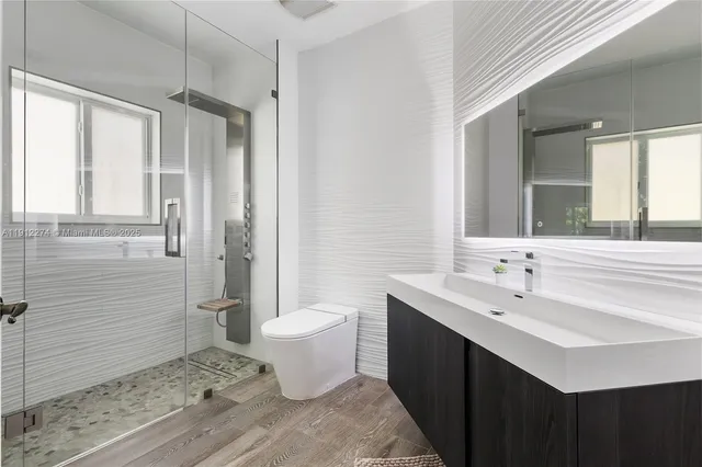 a bathroom with a double vanity sink a toilet and a mirror