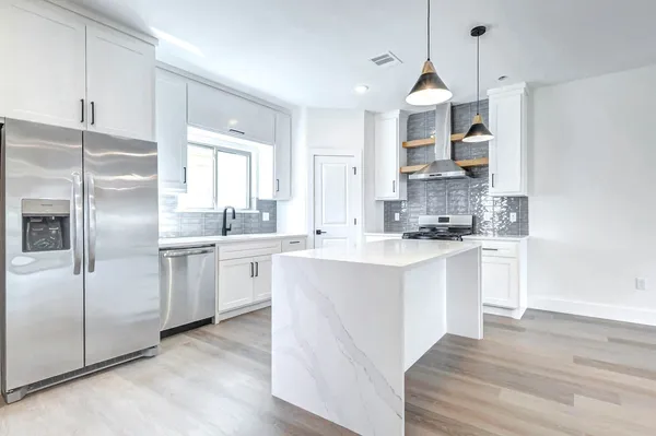 a kitchen with white cabinets and white appliances