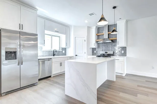 a kitchen with white cabinets and white appliances