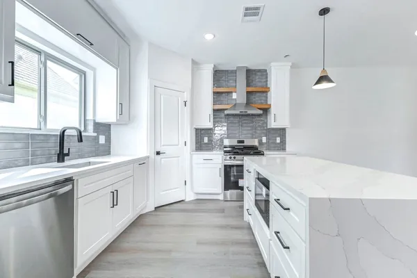a large kitchen with stainless steel appliances kitchen island granite countertop a sink and cabinets
