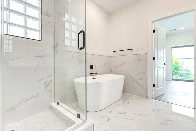 a white bath tub sitting next to a shower