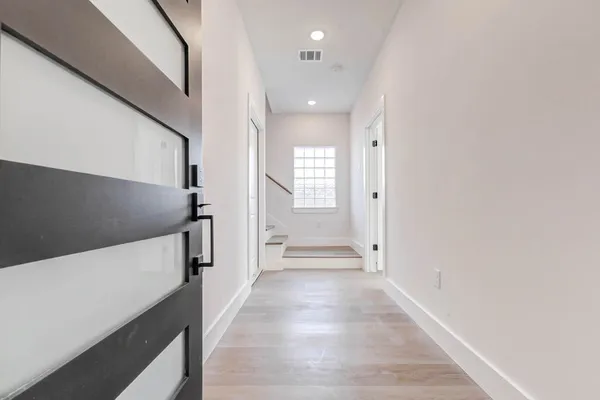 a view of a hallway with wooden floor and staircase