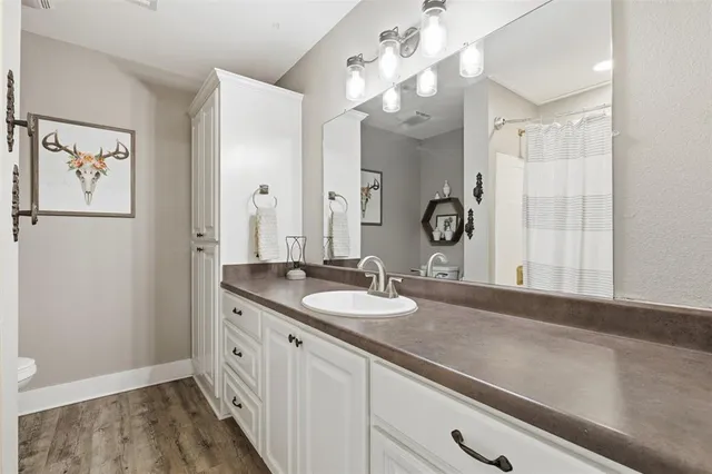 a bathroom with a granite countertop sink a large mirror and a shower