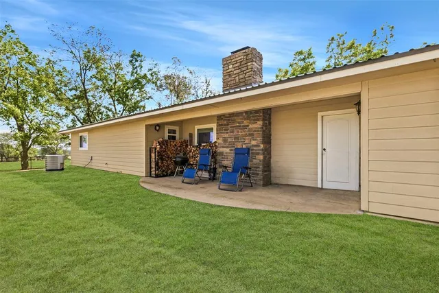 a view of a backyard with table and chairs and potted plants