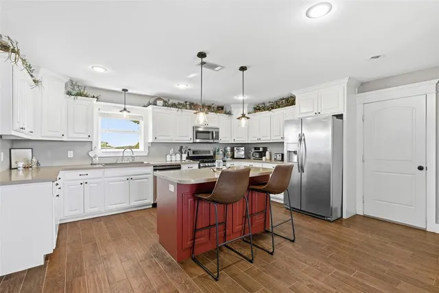 a kitchen with kitchen island granite countertop wooden floors and stainless steel appliances