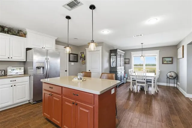 a kitchen with a table chairs refrigerator and cabinets