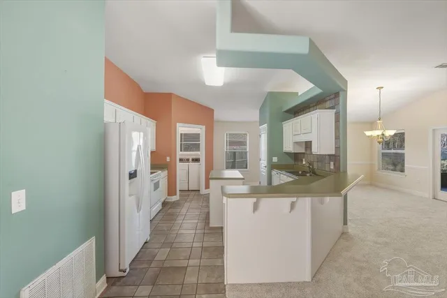 a large white kitchen with cabinets