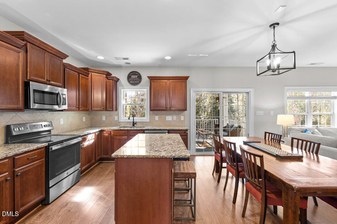 170 Valley Pines Circle Spring Lake, NC 28390 - Photo 16 of 55 a kitchen with stainless steel appliances granite countertop wooden floors a stove a sink a dining table and chairs