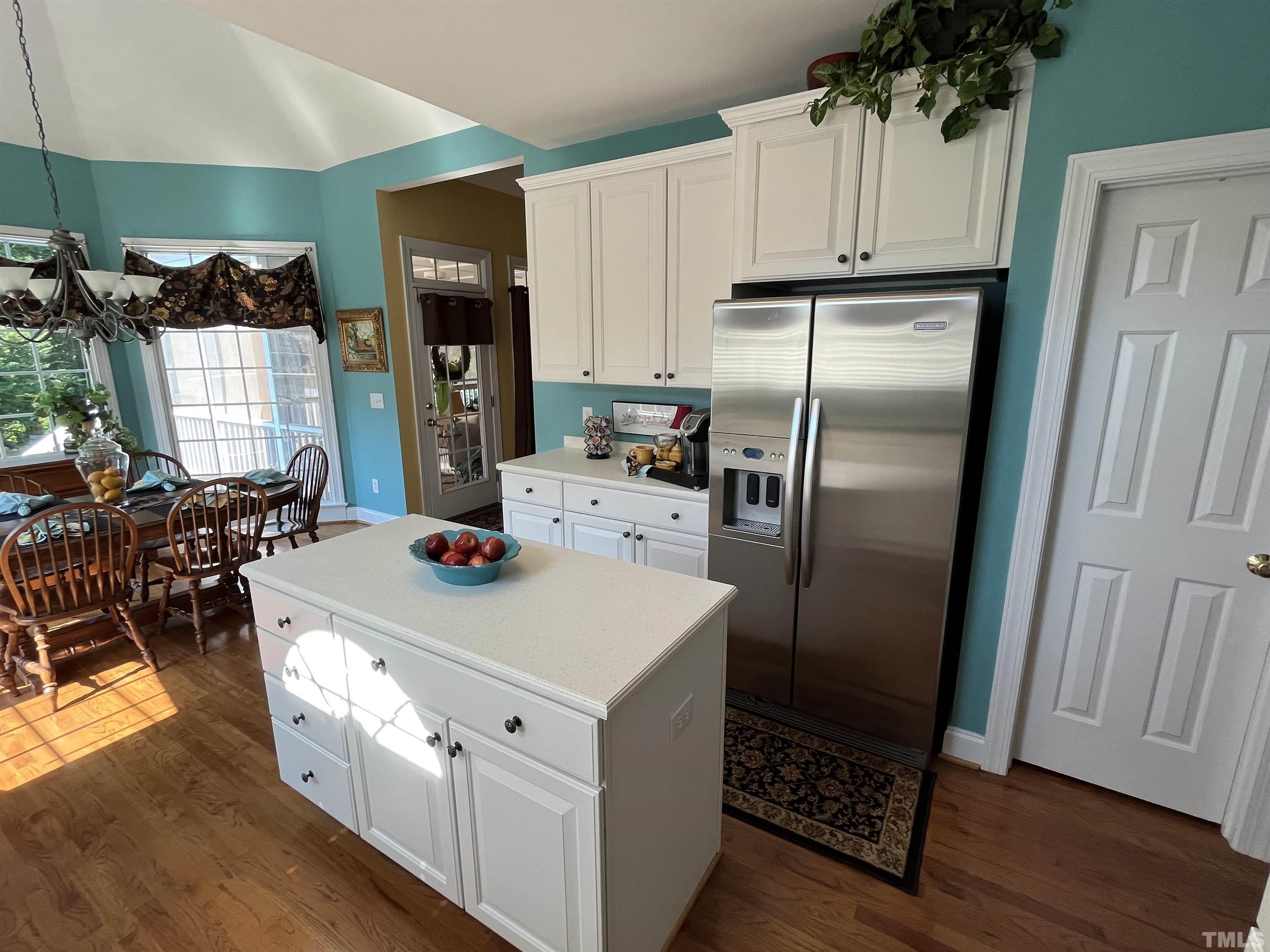 204 Challenge Road Raleigh, NC 27603 - Photo 17 of 42 a kitchen with stainless steel appliances kitchen island granite countertop a refrigerator a stove and a wooden floors