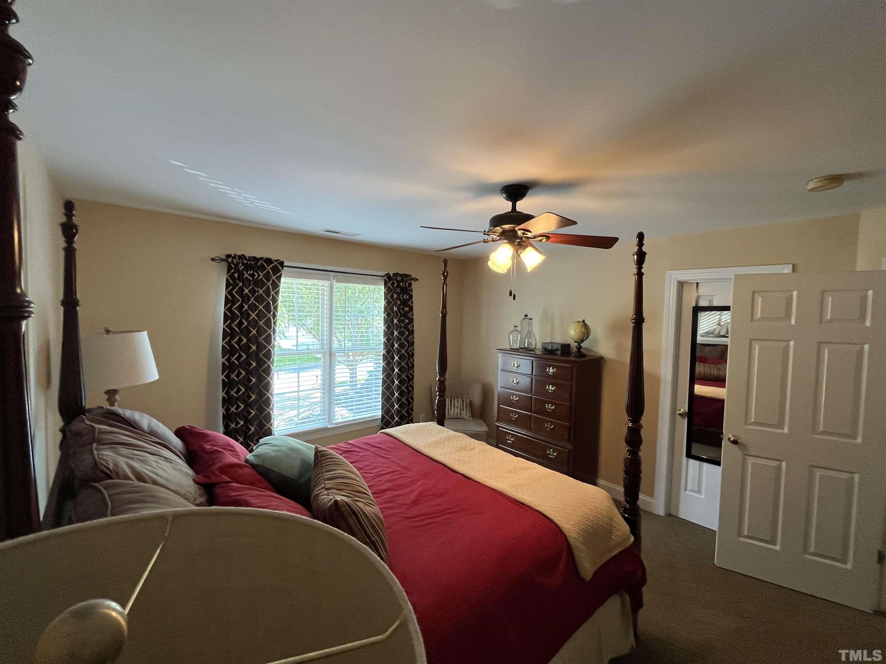 204 Challenge Road Raleigh, NC 27603 - Photo 31 of 42 a bedroom with a large bed and a chandelier