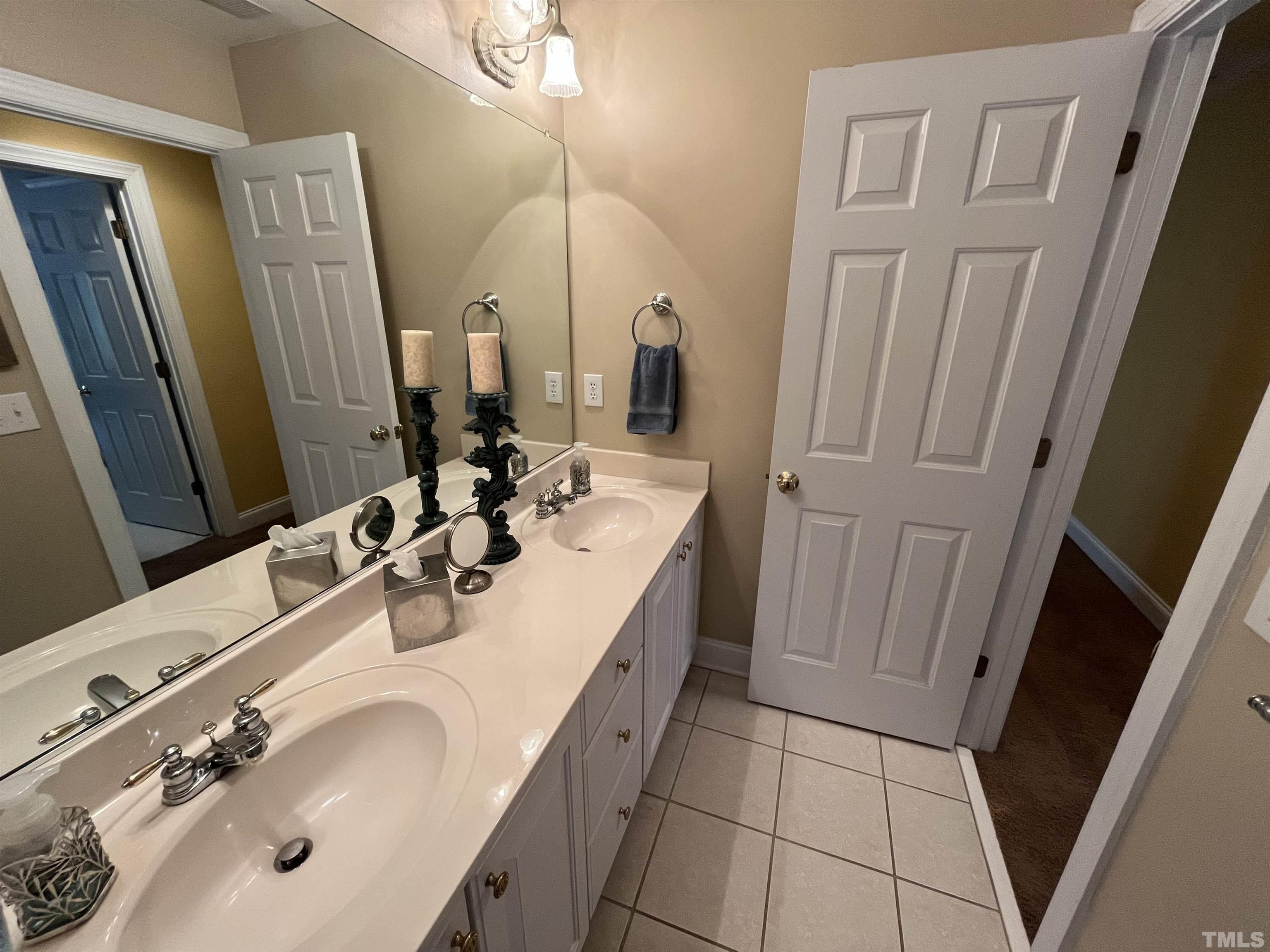 204 Challenge Road Raleigh, NC 27603 - Photo 33 of 42 a bathroom with a double vanity sink and mirror
