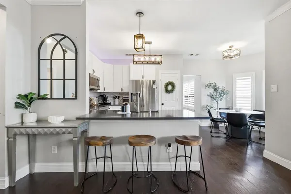 a dining room with furniture a chandelier and wooden floor