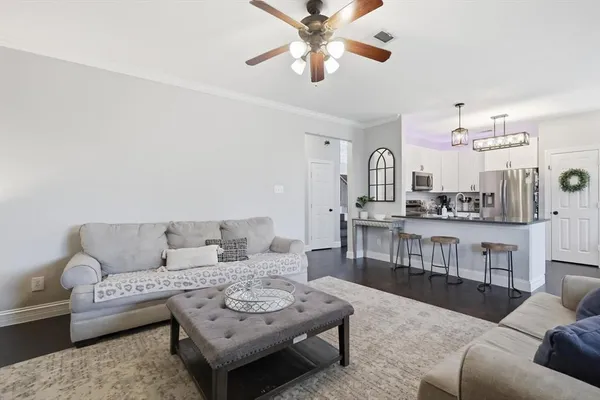 a living room with furniture and view of kitchen