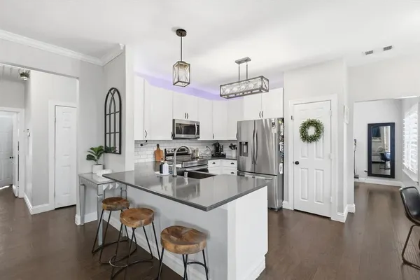 a kitchen with stainless steel appliances kitchen island granite countertop a refrigerator and microwave