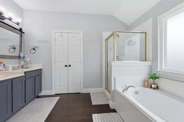 a bathroom with a tub sink and mirror