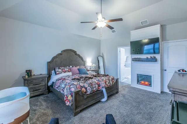 a bedroom with a bed a fireplace and a television