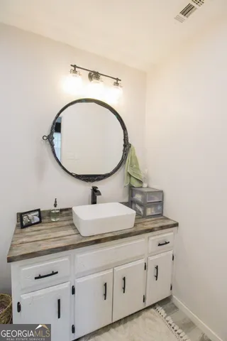 a bathroom with a granite countertop double vanity sink and a mirror