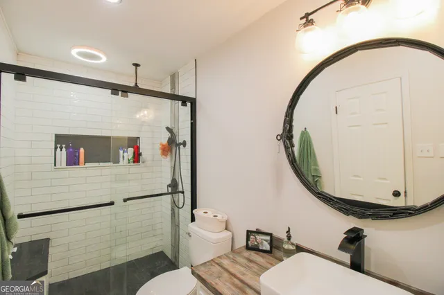 a bathroom with a sink mirror toilet and vanity
