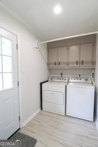 a utility room with cabinets washer and dryer