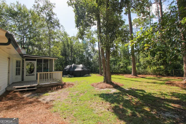 a view of a house with backyard and trees
