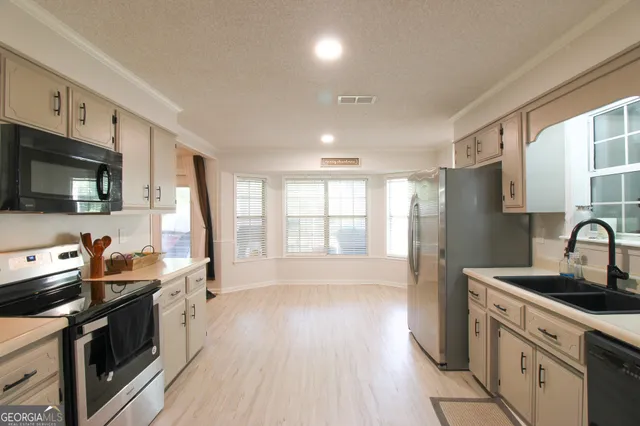 a kitchen with stainless steel appliances a stove sink microwave and cabinets