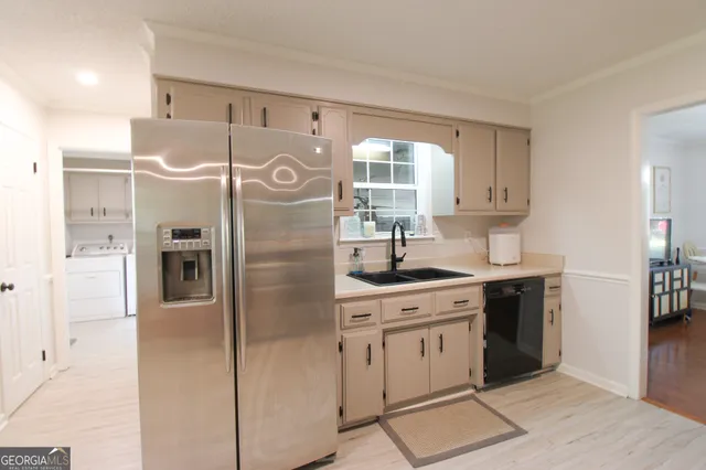 a kitchen with stainless steel appliances a refrigerator sink and cabinets