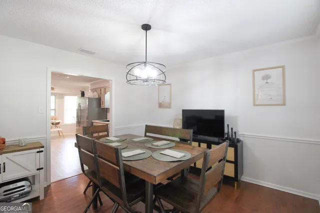 a view of a dining room with furniture wooden floor and a chandelier