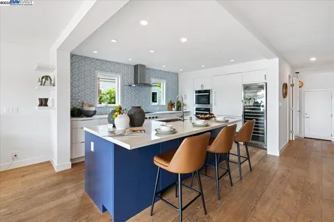 a kitchen with stainless steel appliances kitchen island granite countertop a sink and a refrigerator