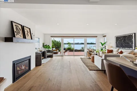 a living room with furniture a fireplace and a large window