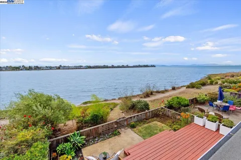 a view of a balcony with wooden floor and lake view