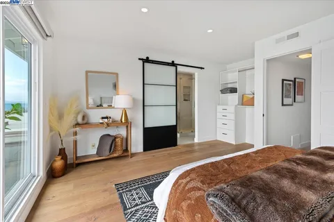 a bedroom with a bed and a large mirror