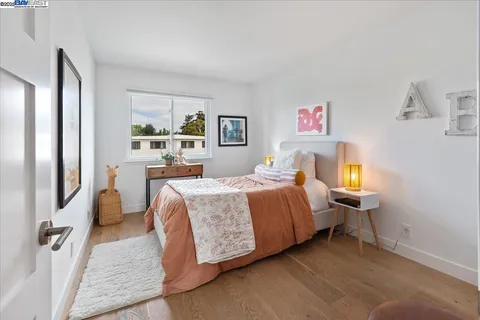 a bedroom with a bed and a painting on the wall