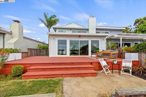 a backyard of a house with garden and outdoor seating